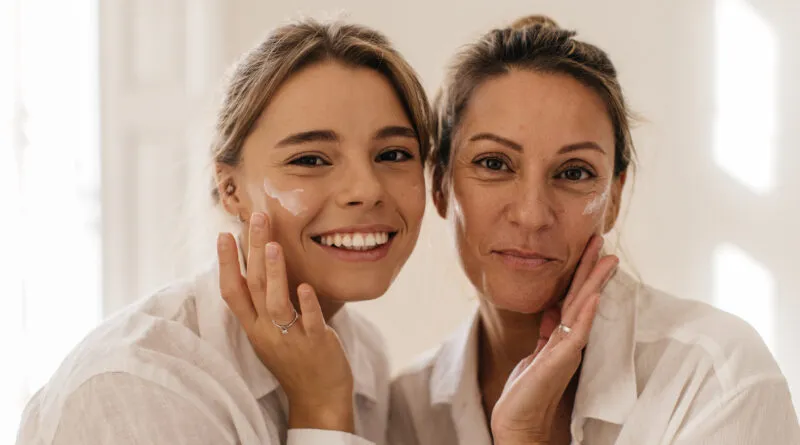 Uma jovem junto com sua mãe passando creme para facial em busca de uma pele radiante